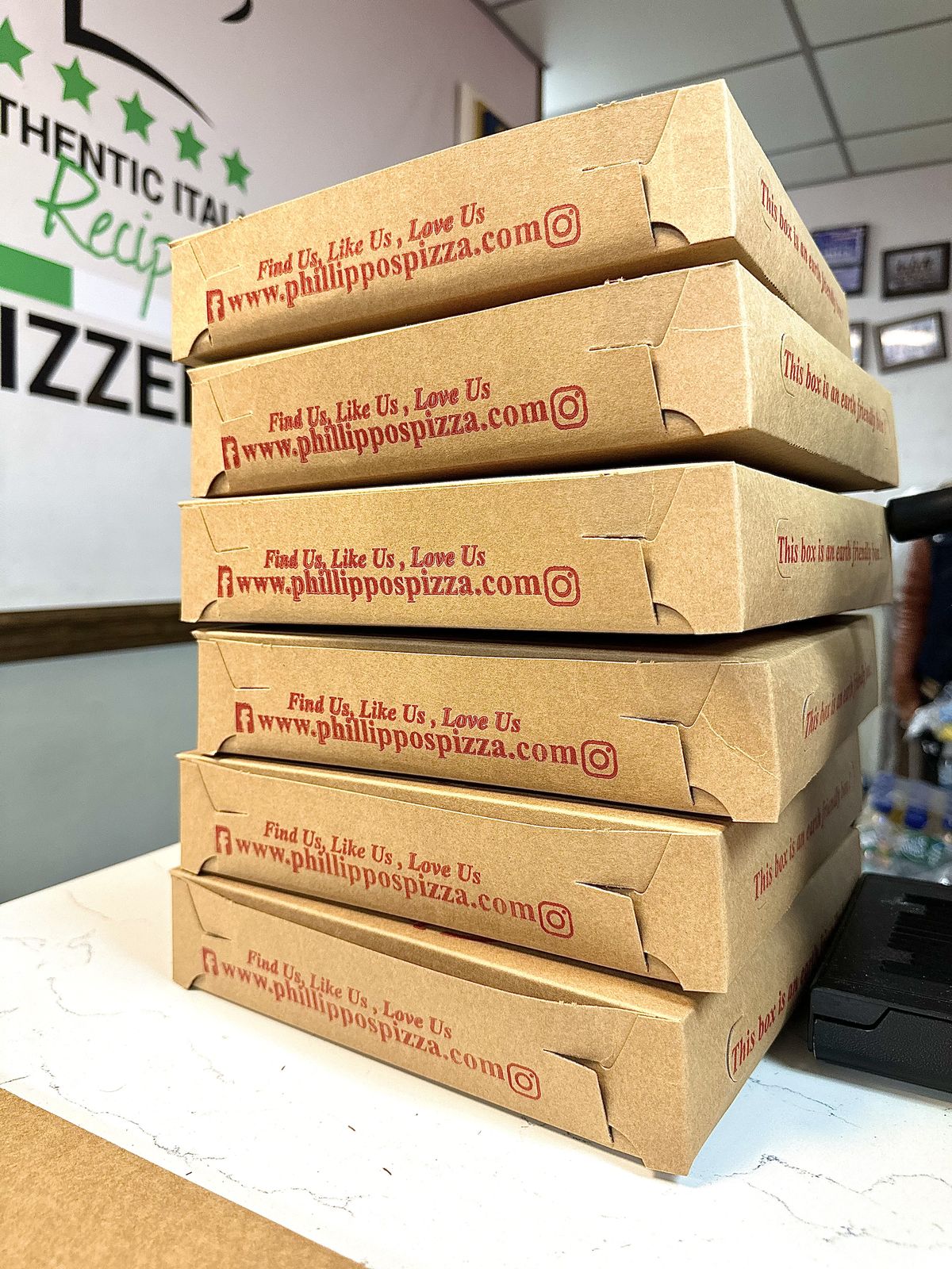 A tall stack of Phillippo's pizza boxes ready for delivery