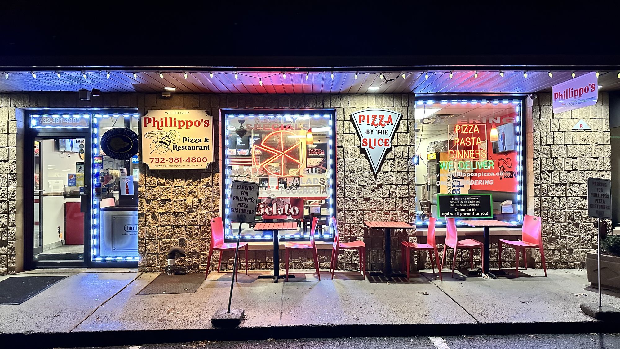Phillippo's Pizza storefront in Clark Village Shopping Center at night