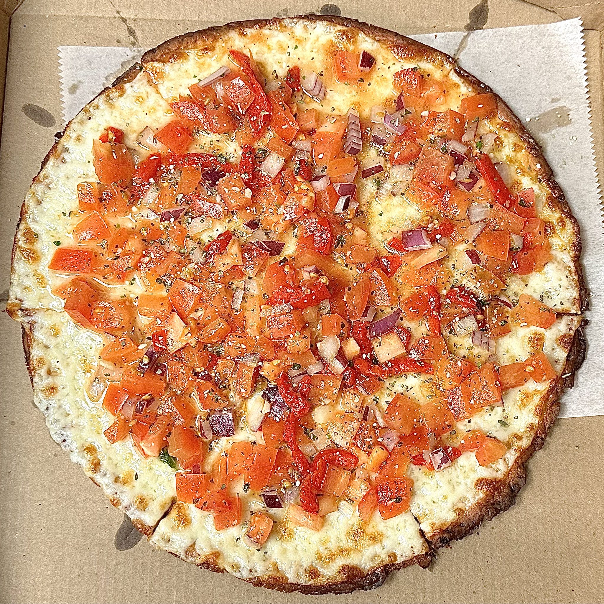 Pizza With Diced Tomatoes And Red Onions On Melted Cheese In A Cardboard Box.