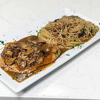 A White Rectangular Plate With Mushroom Topped Chicken In Sauce Alongside A Serving Of Spaghetti, Garnished With Herbs.